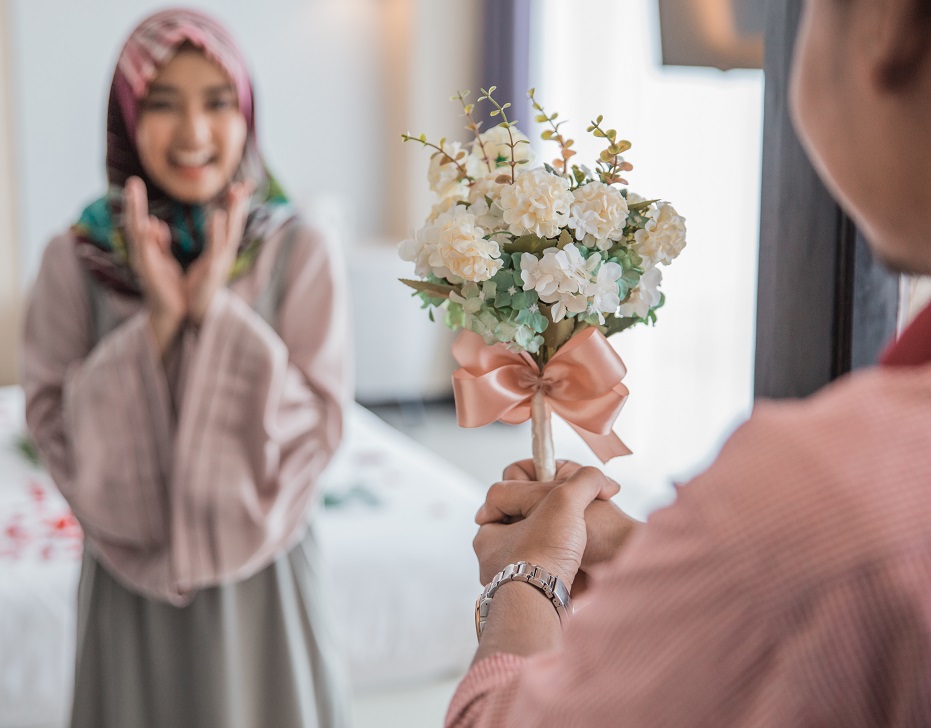 muslim woman having a flower from man